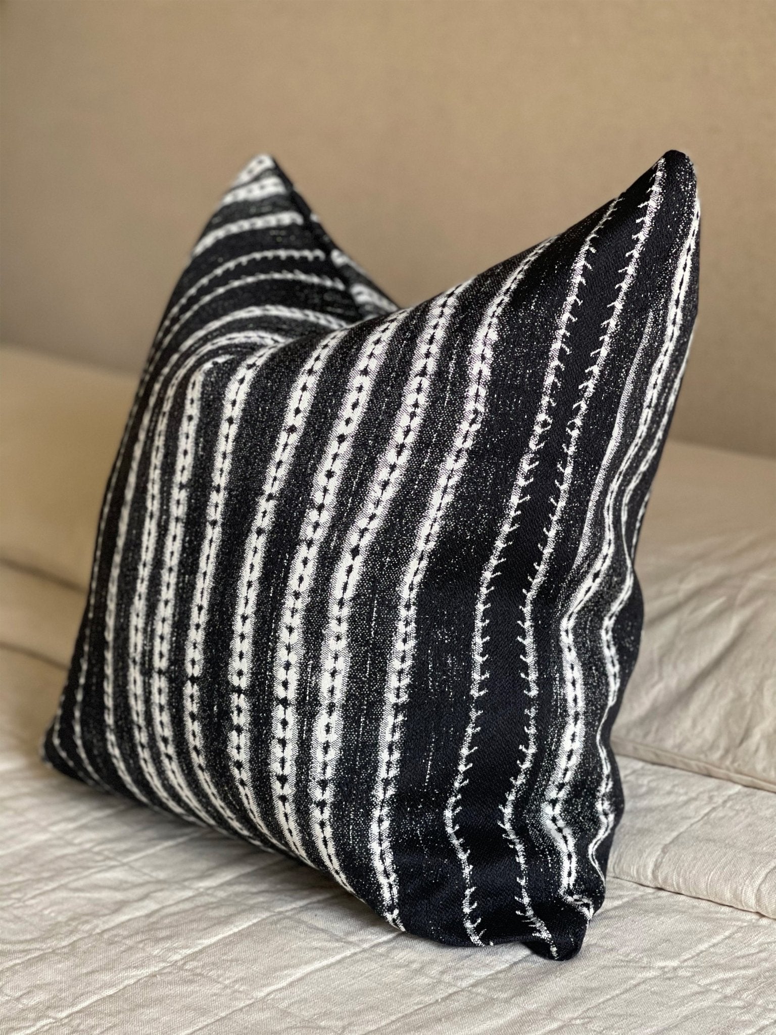 A throw pillow in black and white stipes adds bold contrast impact to your space