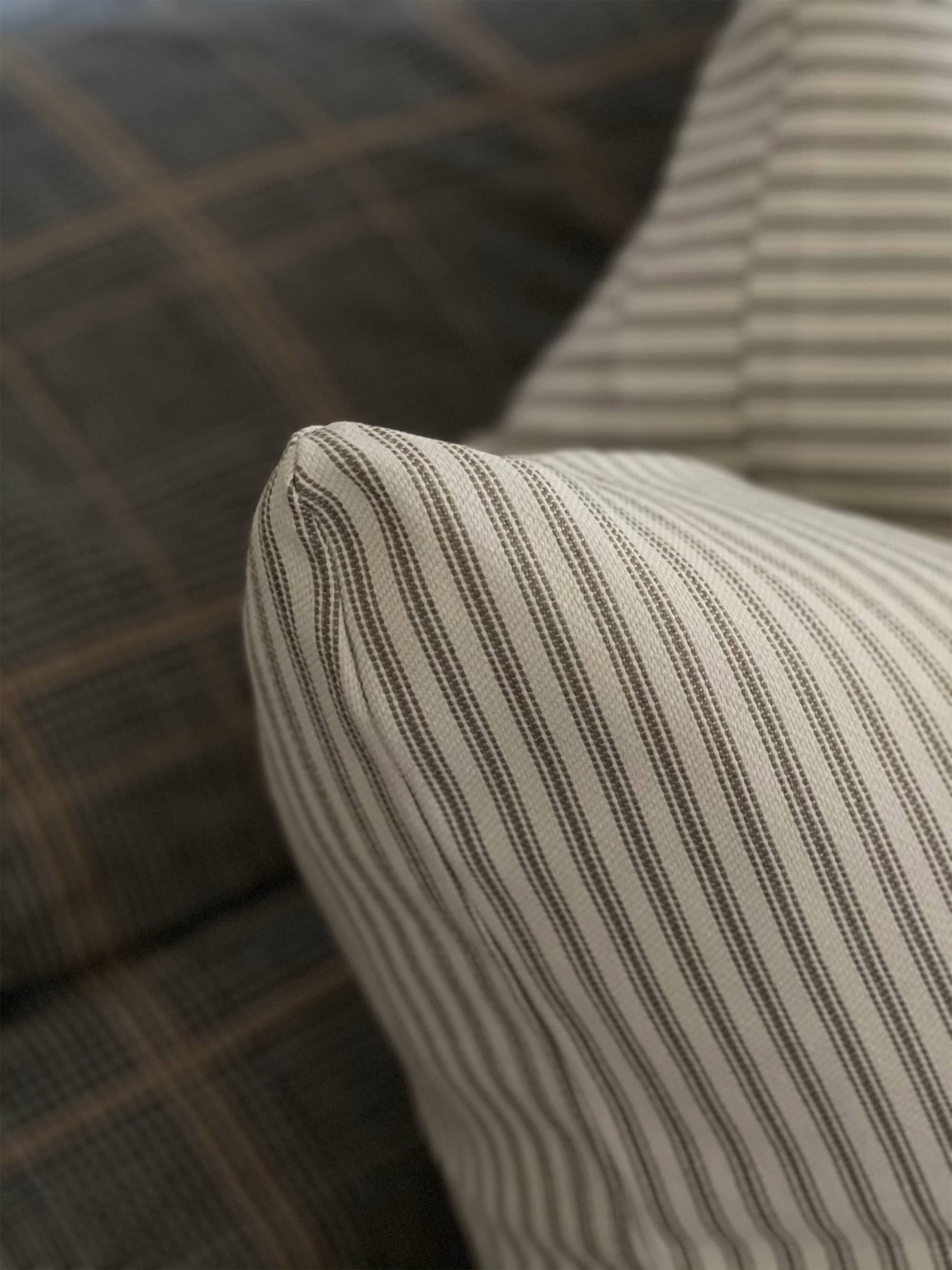 A detailed view on cream colored classic striped pillow cover,