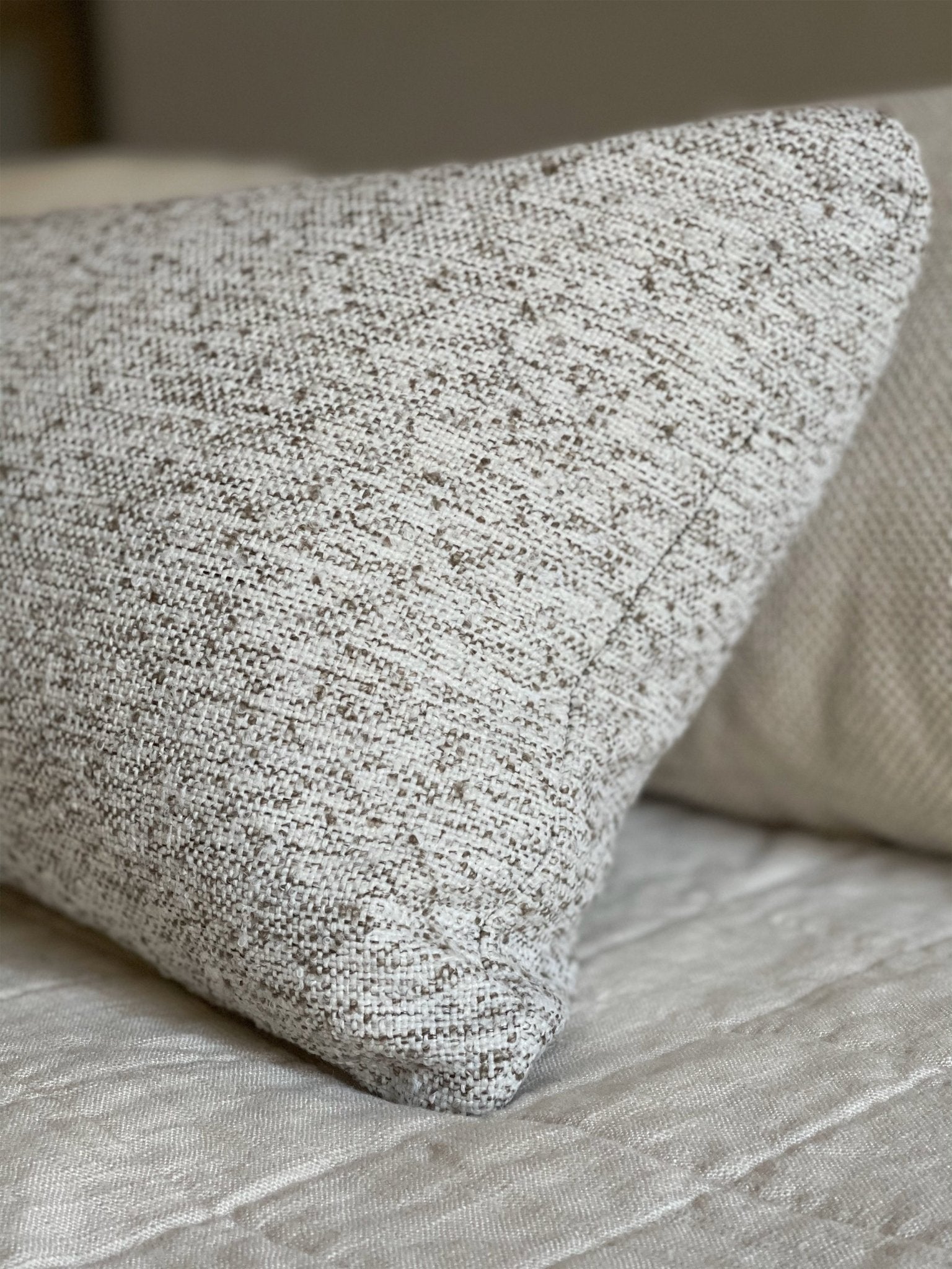 A detailed view of the brown speckled boucle throw pillow cover showing its craftsmanship at Cielle Home