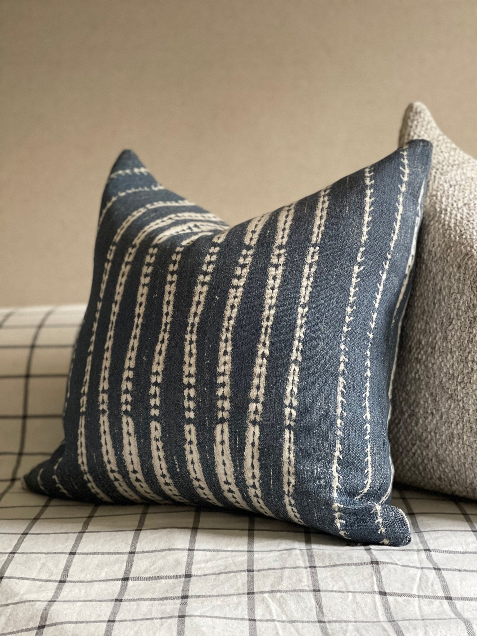 A side view of the blue and white striped decorative pillow showing its craftsmanship at Cielle Home