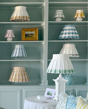 Shelves with various lamps and decorative items against a teal wall at Cielle Home